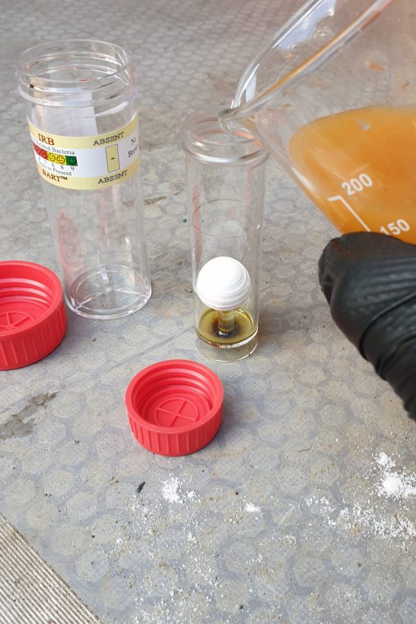 Photo shows a water sample being poured into the test vial